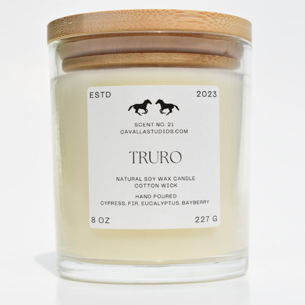 Classic white candle in a clear glass vessel covered by a bamboo lid. The glass features the 'Cavalla Studios' logo and the candle is labeled with the scent name 'Truro.'